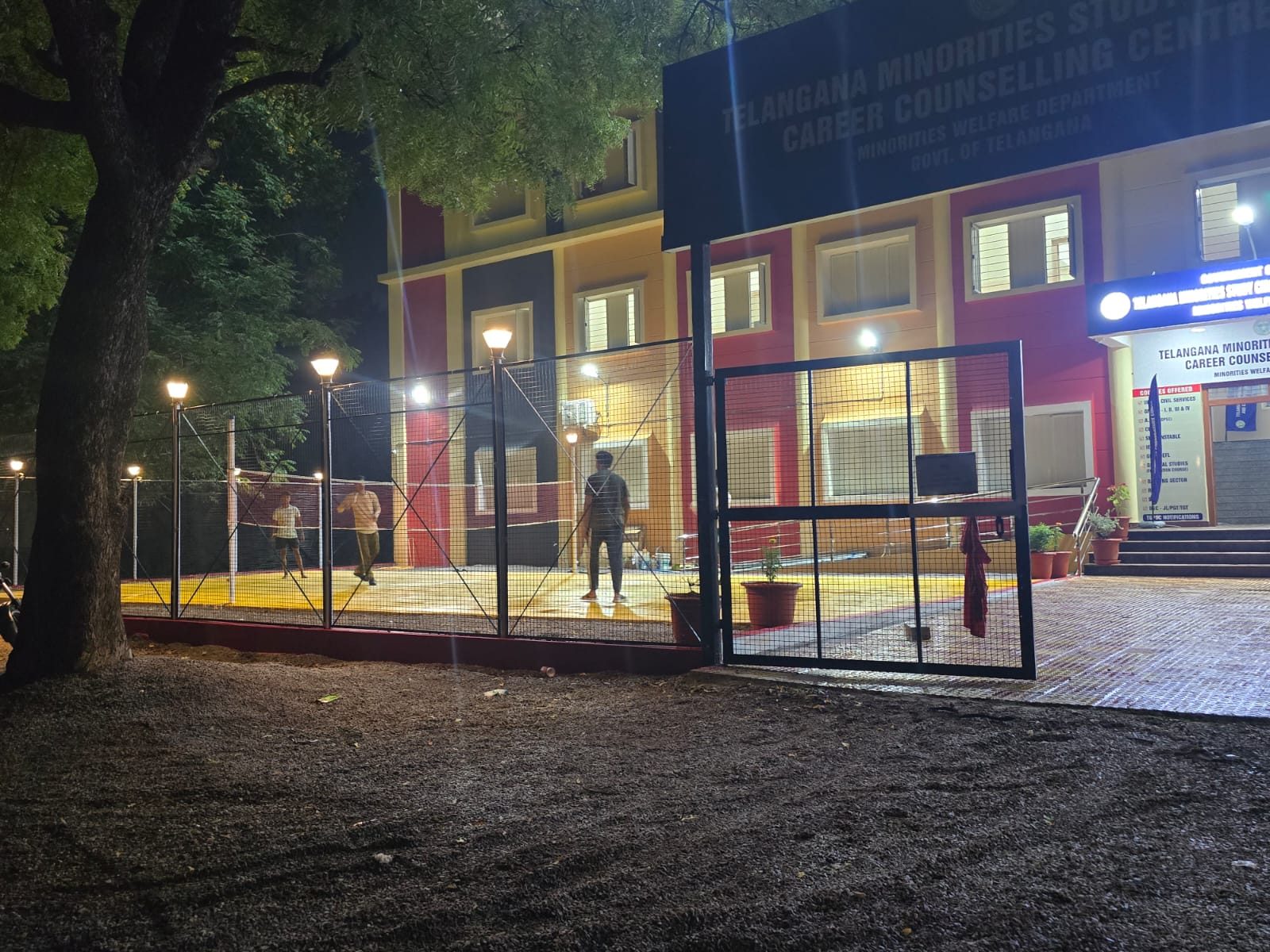 Students playing badminton at the floodlit campus recreation court