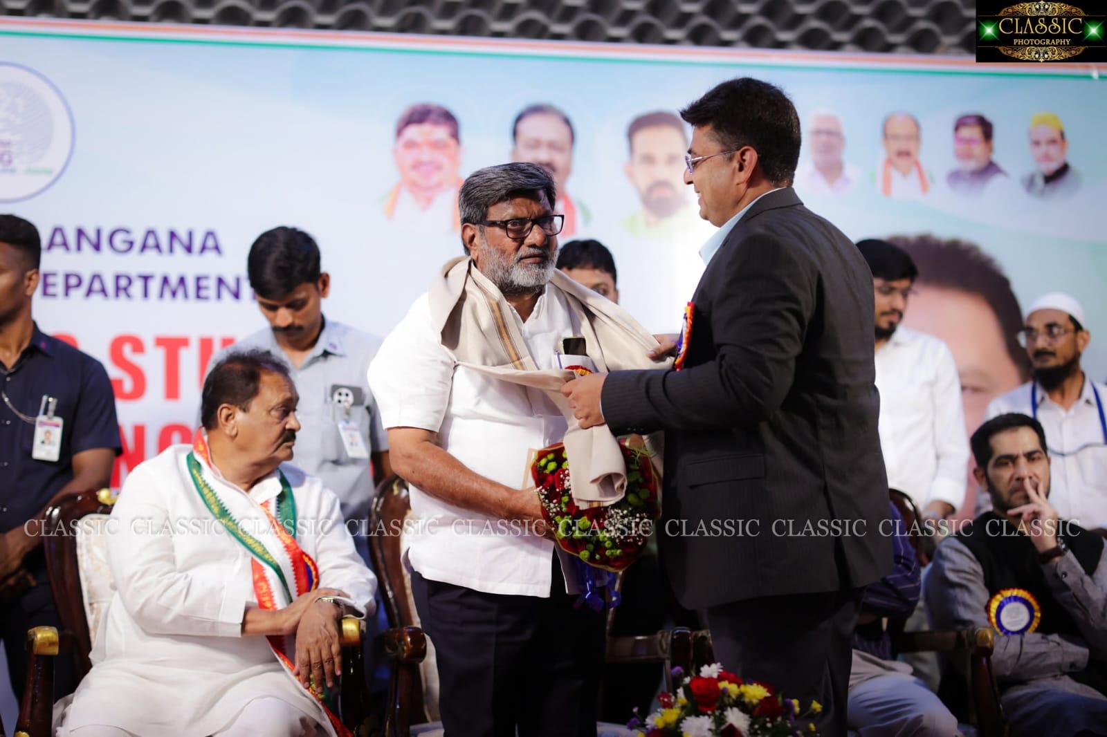 Official being felicitated with a shawl on stage